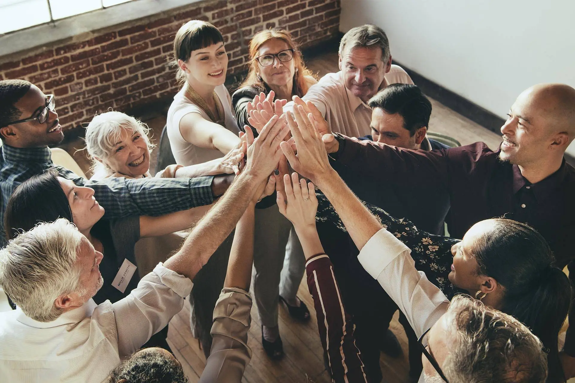 diverse professionals standing together high fiving